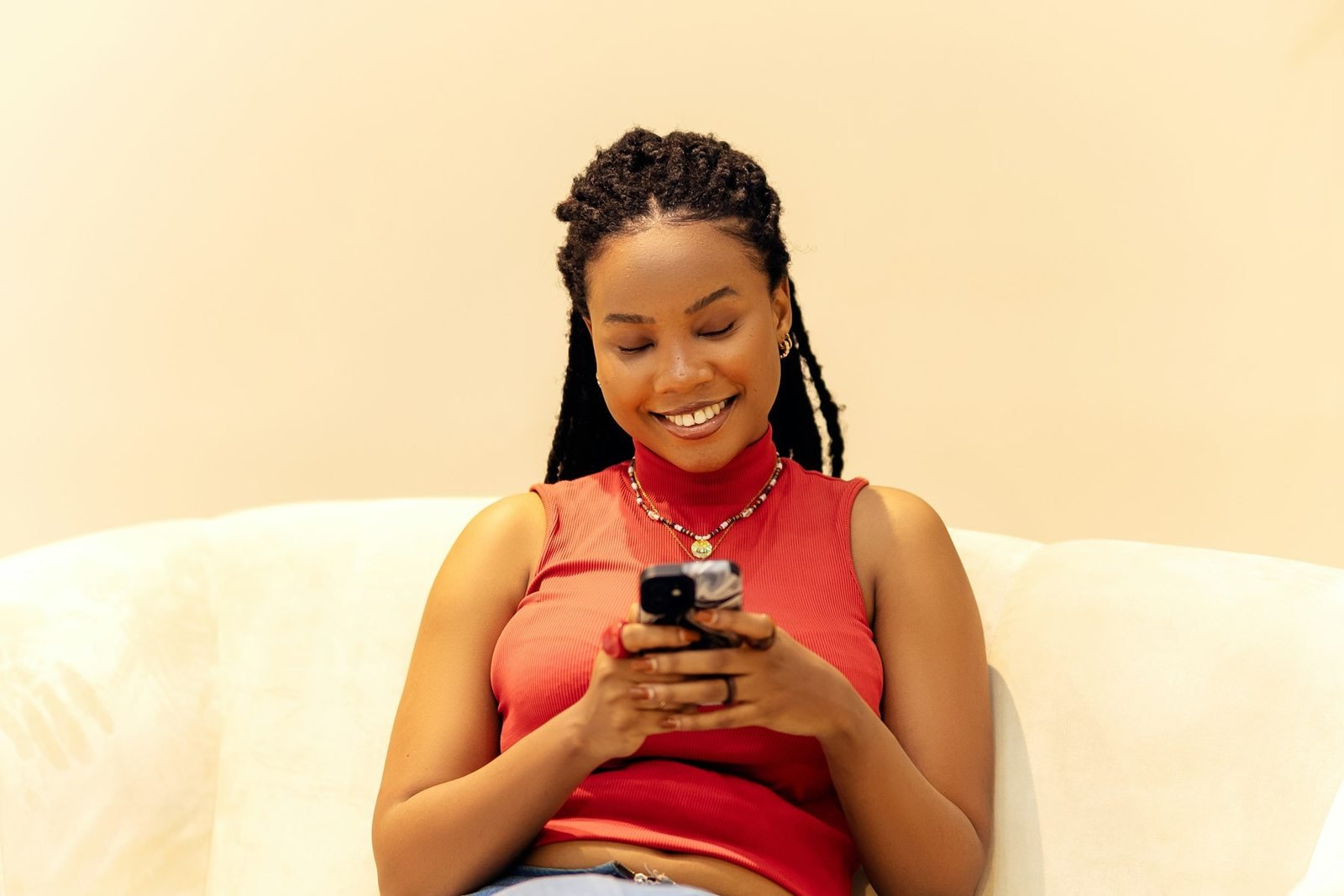 Une jeune femme utilise son smartphone dans un intérieur à Lagos.